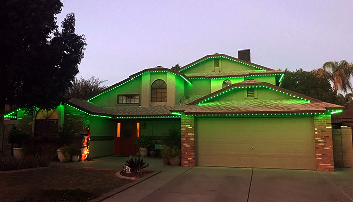 Green St. Patrick's Day lights on a home at dusk