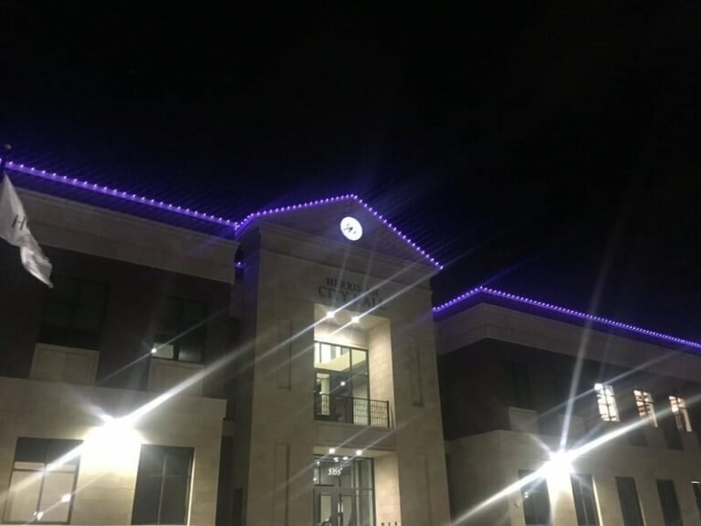 Office building with purple roofline lights at night