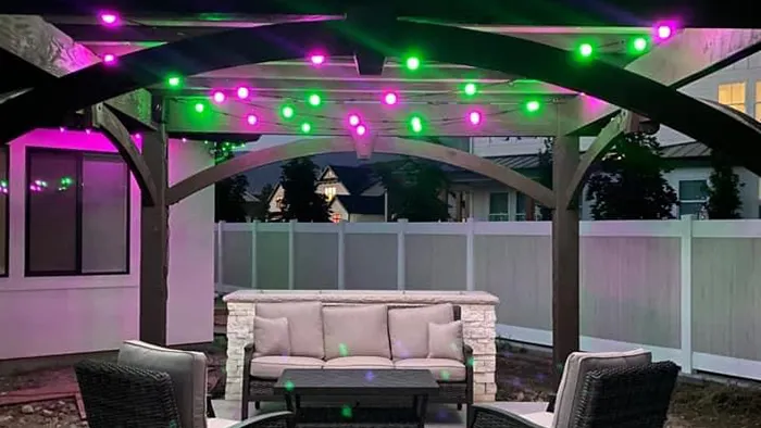 Pink and green globe lights over a patio pergola
