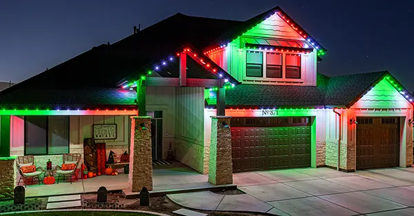 Red and green Christmas lights on a two-story home