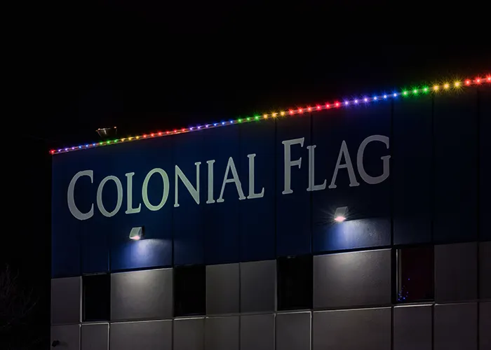 Retail building with rainbow roofline lights and lit signage