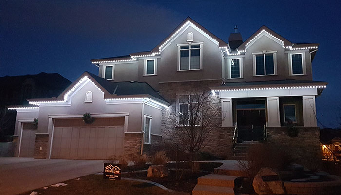 White permanent lights on a two-story home at dusk