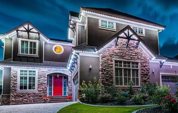 White permanent security lights on a stone two-story home