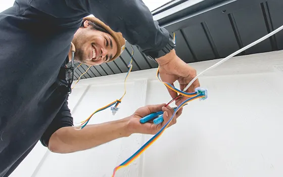 Smiling installer holding an LED light strip under the eave