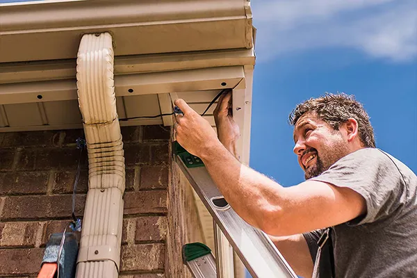 Installer mounting a light channel next to a gutter