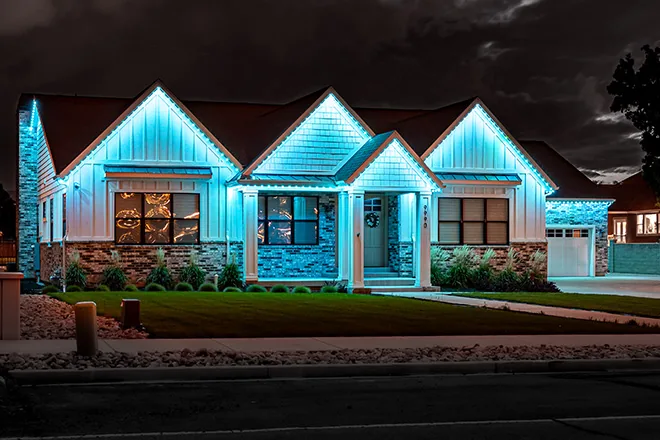 Ice blue permanent lights on a white ranch home