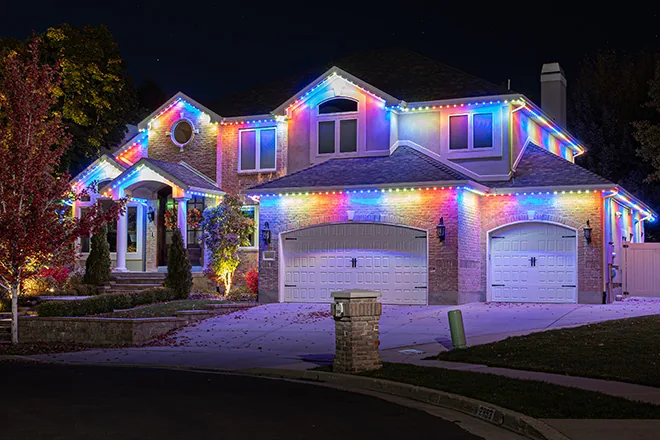 Rainbow permanent lights on a two-story home on a cul-de-sac