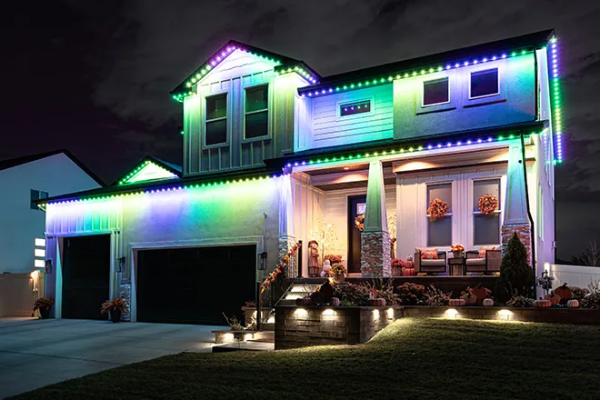 Rainbow permanent lights on a two-story home with a front porch