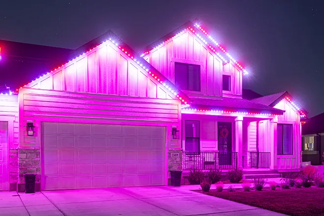 Magenta permanent lights on a two-story home