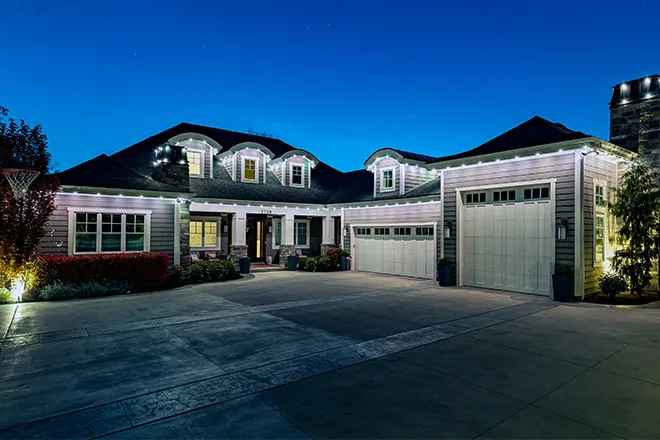 White permanent lights on a ranch home at dusk
