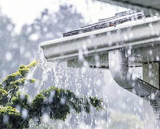 Heavy rain pouring off a gutter and roofline