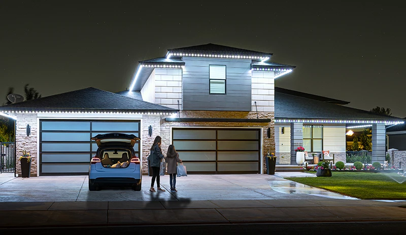White security lights on a modern home with a family in the driveway